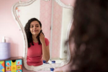 Over the shoulder view of a teenage girl reflection in the mirror