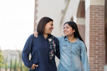 Latin mother and teenage daughter smiling together