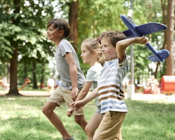 Group of kids playing together with airplane toy