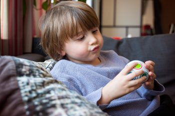 Preschool boy playing logic game at home, smart child solving pu