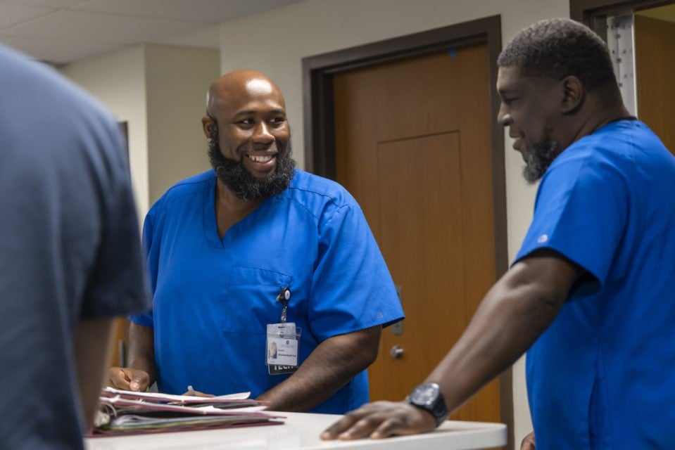 Two behavioral health professionals at Centerstone's hospital smiling while working at a counter.
