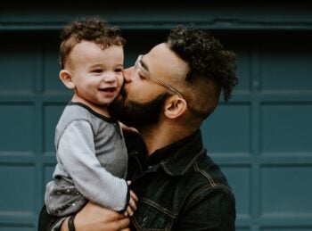 father holding son kiss on cheek