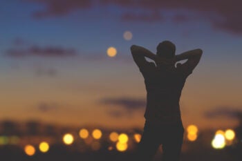 Silhouette of a man with city lights.
