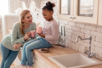 Loving mother feeling happy looking at her adopted daughter