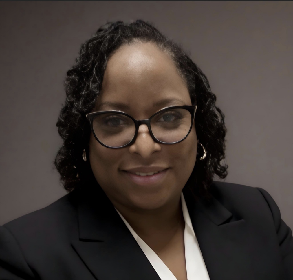 Portrait of Tonetta Everett wearing glasses, a dark blazer, and a light blouse.